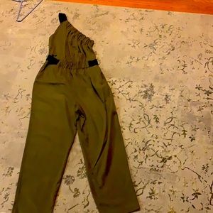 Green jump suit. One shoulder with black banding.